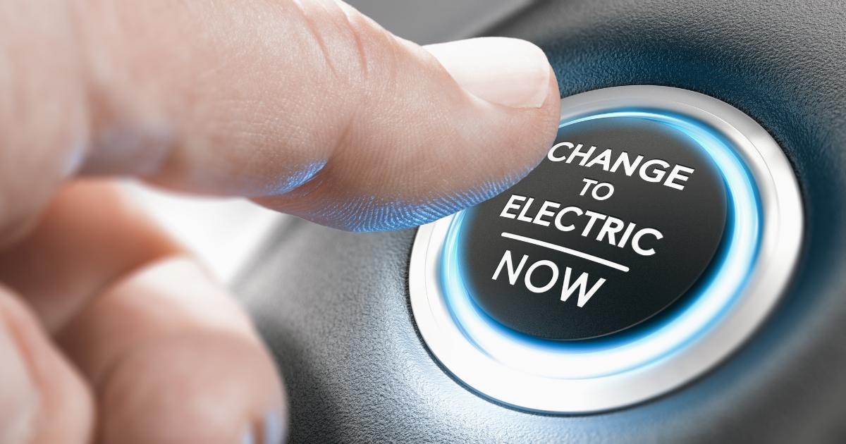 A finger poised to press the start button of a car